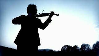 大自然中小提琴家的剪影视频素材模板下载