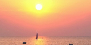 游艇驶向粉红色的夕阳
