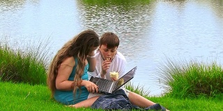 一个女孩和一个男孩带着笔记本电脑。
