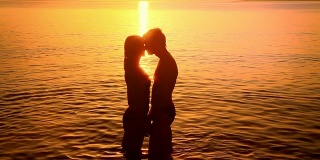 一对情侣在日落时接吻的剪影