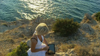 HD CRANE:女性游客在海边使用石碑视频素材模板下载