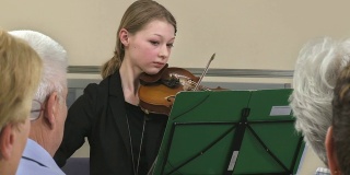 年轻的女小提琴手正在演奏小提琴