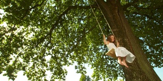 高清慢动作:小女孩在树上荡秋千