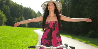 骑自行车的年轻女子双手解放了