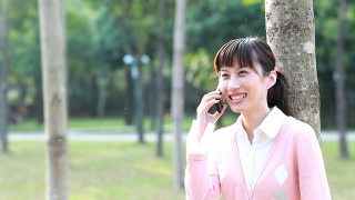 年轻的亚洲女人在打电话，面带微笑视频素材模板下载