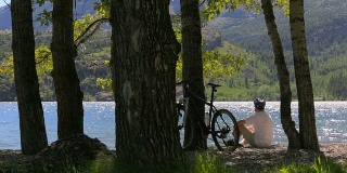 骑自行车的人坐在湖边
