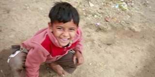 一个兴高采烈的印度乡村男孩看着相机