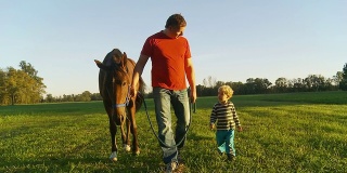 HD STEADY: Father And Son Walking A Horse