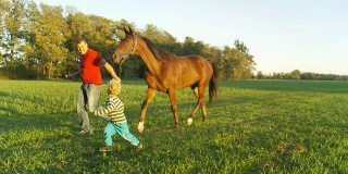 HD STEADY: Man And Little Boy Walking A Horse