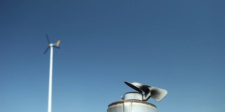 蓝天下的烟囱和风力涡轮机