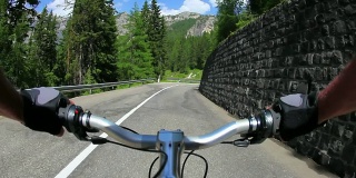 HD骑着自行车沿着一条高山路下山