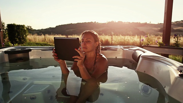 用平板电脑泡热水澡的女人