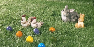 小兔子，小鸡和彩色的蛋躺在绿色的草地上