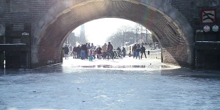 在冰冷的阿姆斯特丹运河桥下滑冰