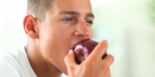 年轻人一边吃苹果一边看别处