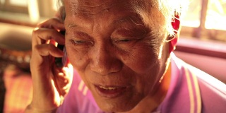 一个年长的亚洲人在打手机