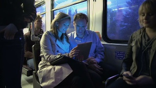 在公交车上玩平板电脑的通勤者视频素材模板下载