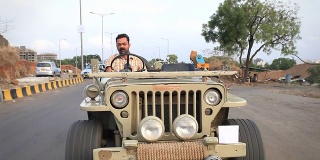 一名印度男子开着一辆老式吉普车