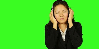 美丽的商业女性听音乐与绿色的屏幕背景