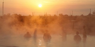 温泉在日出，人们在游泳