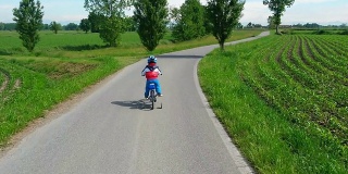 蹒跚学步的孩子正在学习骑他的新自行车