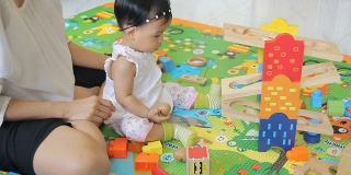 小女孩和妈妈玩木头玩具