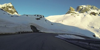 日落时分，车辆POV在雪山路上行驶