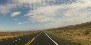 POV从汽车沿着沙漠道路行驶