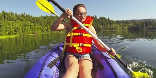 一个女孩在湖中划着皮划艇