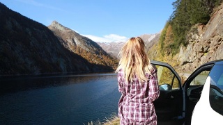 女人下车，拍下美丽的山湖视频素材模板下载