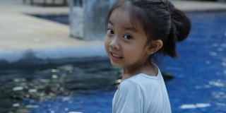 小女孩笑着游泳池