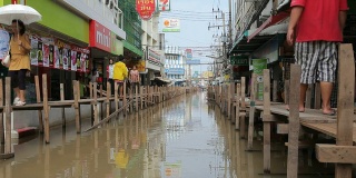 在泰国，人们在雨季洪水中行走