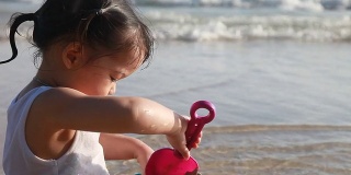 近距离拍摄女孩和她的玩具在海滩上