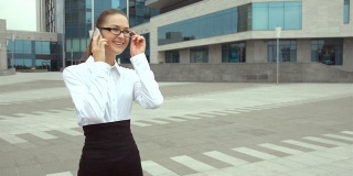 年轻漂亮的女商人戴着眼镜用智能手机聊天