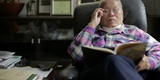 老人在读一本书