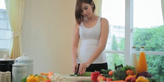 快乐女人烹饪蔬菜绿色沙拉