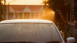 一位女士正在用水雾清洗汽车挡风玻璃视频素材模板下载