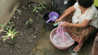 年长的亚洲妇女手洗衣服视频素材模板下载