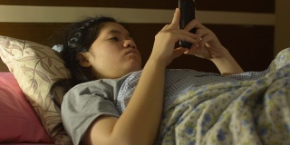 好玩的年轻女人睡觉和玩手机