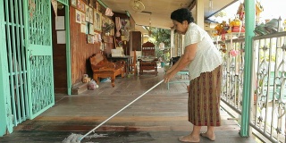 年长的亚洲妇女打扫房子