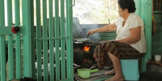 高级亚洲妇女在厨房做饭