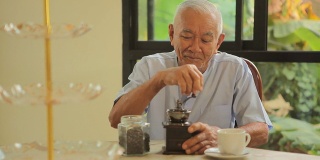 亚洲老人拿着老式咖啡机