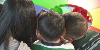 亚洲幼儿园老师在教室里用平板电脑教孩子