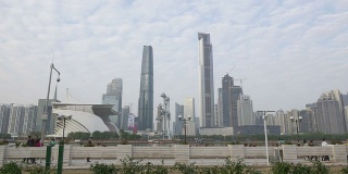 旅游列车穿越以天际线为背景的现代城市广州。