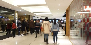亚洲人走在购物中心，时间流逝。