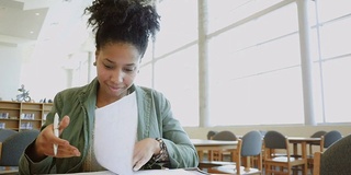 非裔美国成人大学生在灯火通明的图书馆里学习