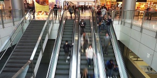 亚洲人在购物中心的自动扶梯上，时间流逝。