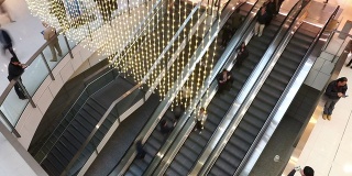 亚洲人在购物中心的自动扶梯上，时间流逝。