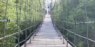 女人在吊桥上散步看风景