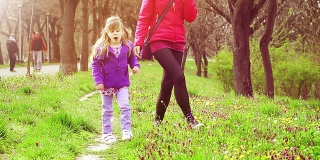 小女孩和妈妈一起在公园里学走路
